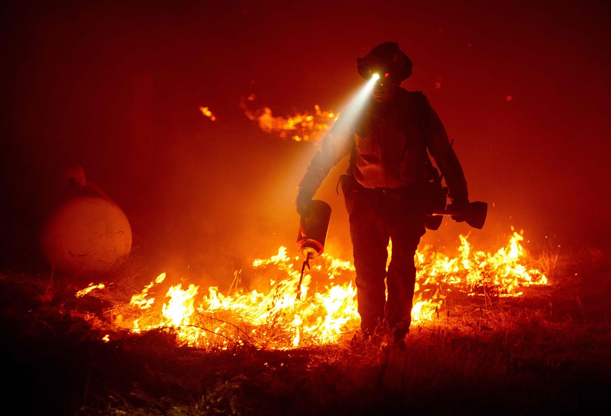 Firefighters cut defensive lines and light backfires to protect structures behind a CalFire fire station during the Bear fire in California on September 9, 2020. Credit: AFP Photo