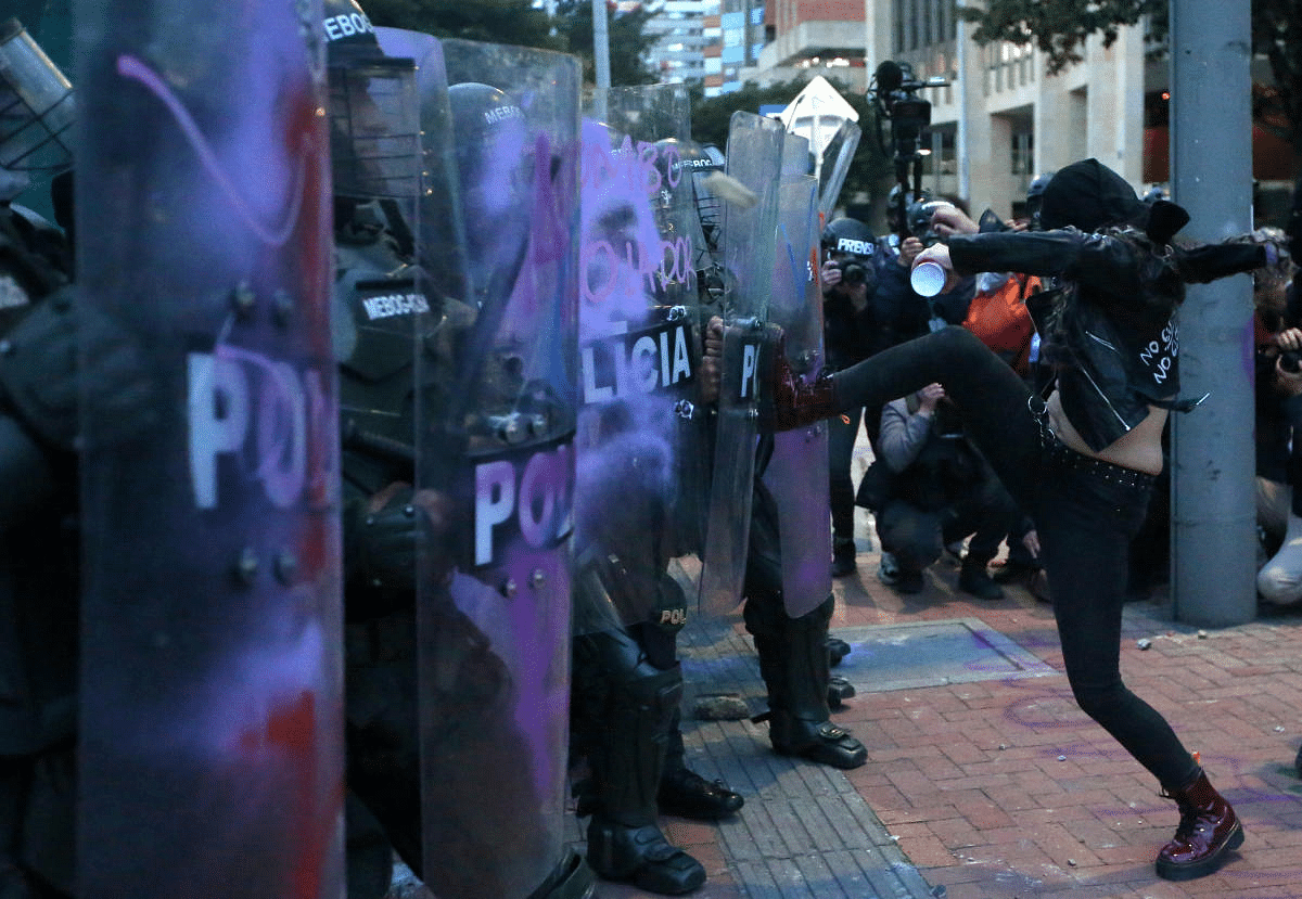 A protester kicks a riot police shield in front of a line of police officers during a demonstration against what protesters say is police brutality in Bogota, Colombia. Credit: Reuters Photo