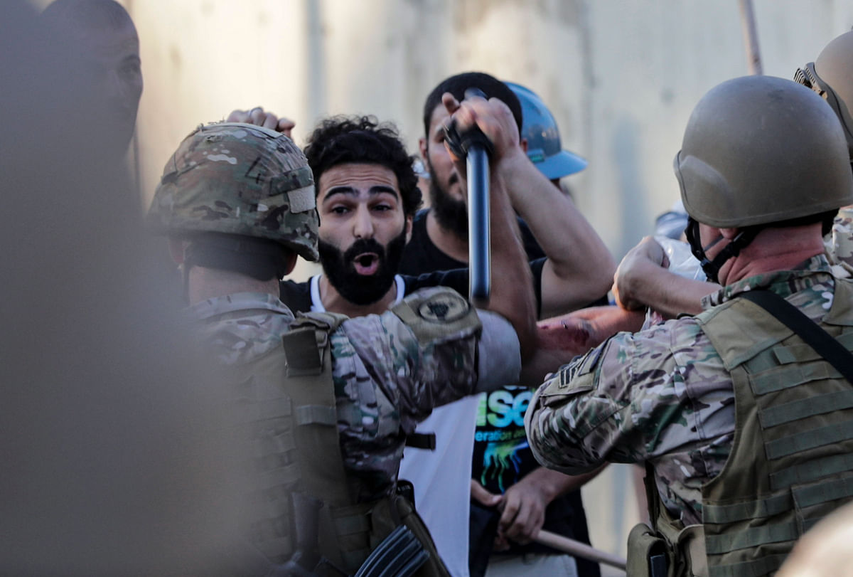 Lebanese protesters scuffle with security forces during a demonstration against the lack of progress in a probe by authorities into a monster blast that ravaged swathes of the capital 40 days ago, near the presidential palace in Baabda, east of the capital Beirut. Credit: AFP