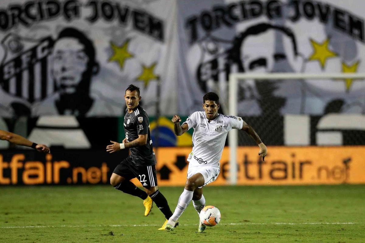 Brazil's Santos forward Raniel (R) dribbles past Paraguay's Olimpia midfielder Willian Candia during their closed-door Copa Libertadores group phase football match at the Vila Belmiro stadium in Santos, Brazil, amid the Covid-19 pandemic. Credit: AFP Photo