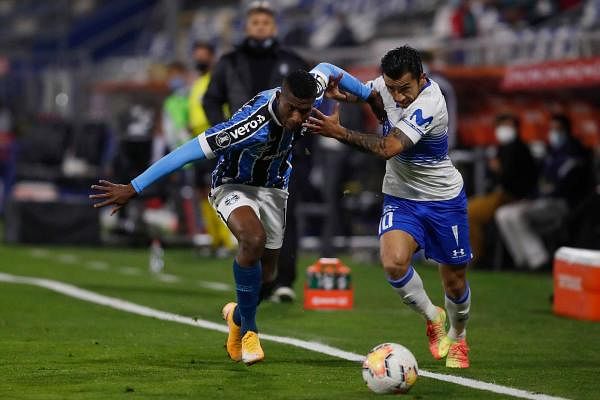 Brazil's Gremio defender, Colombian Luis Orejuela (L) and Chile's Universidad Catolica midfielder Edson Puch vie for the ball during their closed-door Copa Libertadores group phase football match at the Estadio San Carlos de Apoquindo stadium in Santiago. Credit: AFP Photo