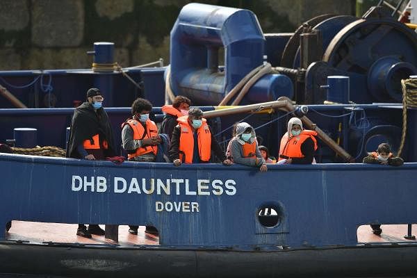 Waleed (3L), 29, a Kuwaiti migrant, stands with other migrants onboard the DHB Dauntless tug boat as they are brought to shore by the UK Border Force after illegally crossing the English Channel from France on a dinghy. Credit: AFP Photo