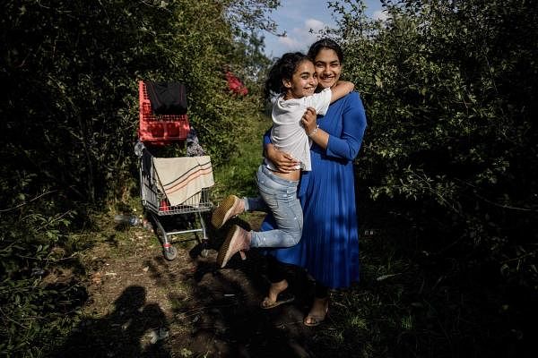Arwa (L), 10, and her sister Rawan, 16, an Iraqi girl, diabetic, pose for a photo at a makeshift migrants camp in Dunkirk, northern France. Credit: AFP Photo