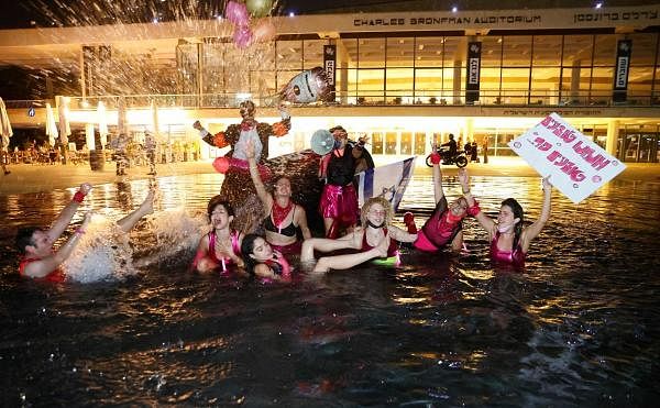 Anti-government demonstrators pose for a picture in the fountain outside the Charles Bronfman Auditorium (Culture Palace) in the centre of Israel's Mediterranean coastal city of Tel Aviv. Credit: AFP Photo