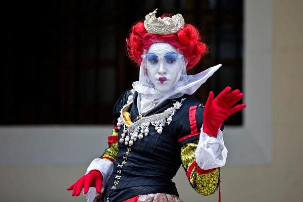 A woman disguised as The Queen of Hearts and wearing a protective, mask works as a living statue at the colonial area in Santo Domingo. Credit: AFP Photo