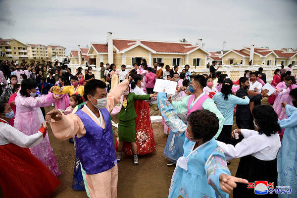 Face masking wearing people of Kangbuk-ri, Kumchon County of North Hwanghae Province, North Korea September 17, 2020 dance during a ceremony before moving into to new houses. Credit: KCNA via Reuters