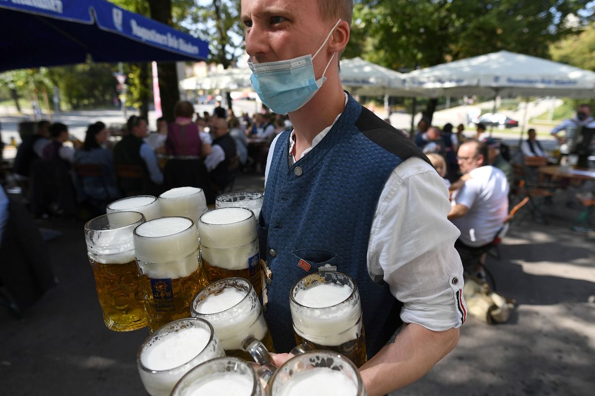 A server carries mugs during a barrel tapping at a beer garden near Theresienwiese where Oktoberfest would have started today as Covid-19 continues in Munich, Germany. Credit: Reuters