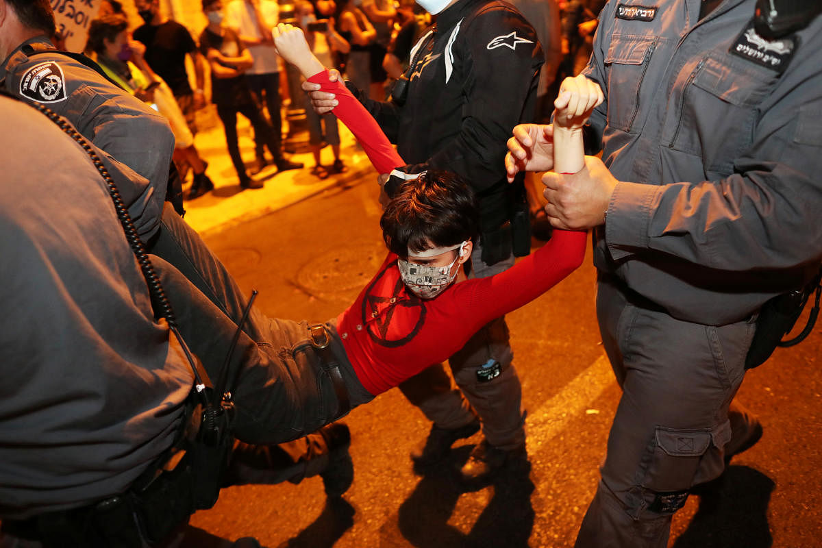 Israeli police carry a woman during a protest against Israeli Prime Minister Benjamin Netanyahu's alleged corruption and economic hardship stemming from lockdown after Israel entered a second nationwide lockdown amid a resurgence in the new coronavirus disease cases, forcing residents to stay mostly at home during the Jewish high-holiday season in Jerusalem. Credit: Reuters Photo