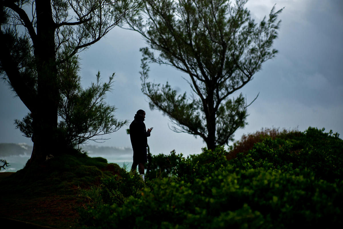 A resident observes the swells and surfs of Hurricane Teddy on the South Shore of the island, as it approaches Bermuda. Credit: Reuters Photo