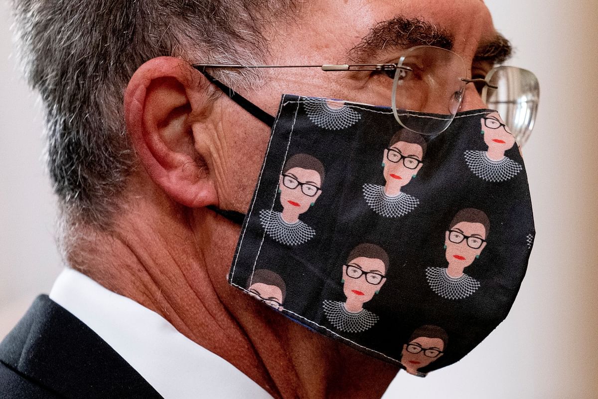 David Reines, the husband of NPR's Nina Totenberg wears a face mask with depictions of Justice Ruth Bader Ginsburg on it during a private ceremony for Justice Ruth Bader Ginsburg at the Supreme Court in Washington, US. Credit: Reuters