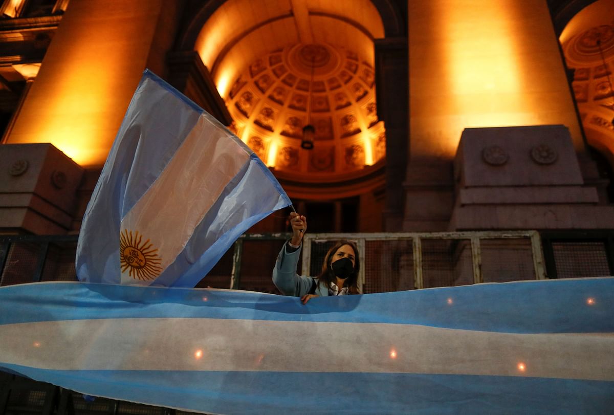 A demonstrator waves an Argentine flag during a protest against a bid to reform the judiciary, in Buenos Aires, Argentina. Credit: Reuters