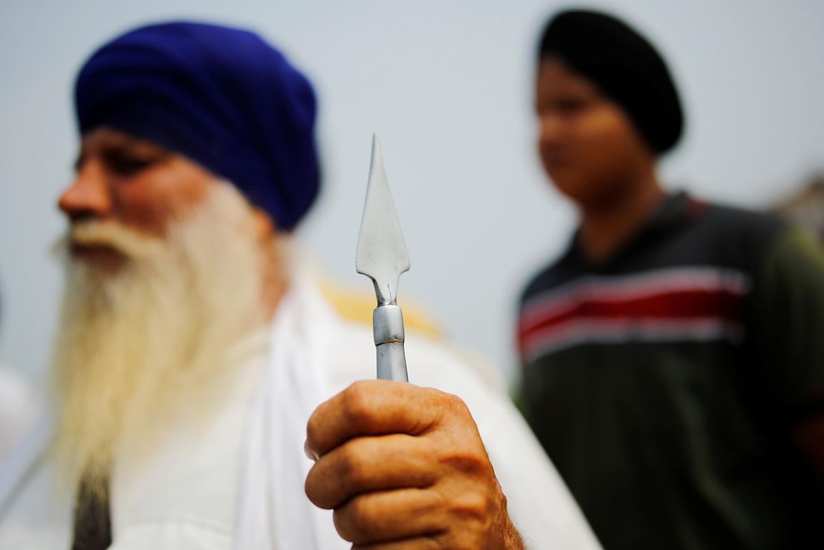 A farmer holds a spear as farmers block a national highway in Punjab. Credit: Reuters