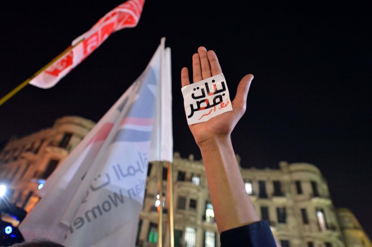 An Egyptian protester holds up his hand with a slogan reading in Arabic: