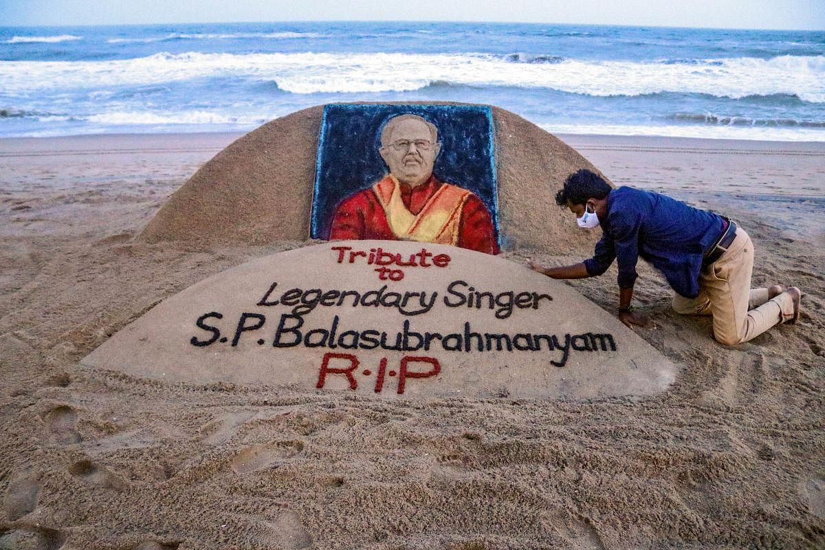 Sand artist Sudarsan Pattnaik gives final touch to a sand sculpture in memory of legendary singer S P Balasubramanyam, who passed away today, at Puri beach, Odisha. Credit: PTI Photo