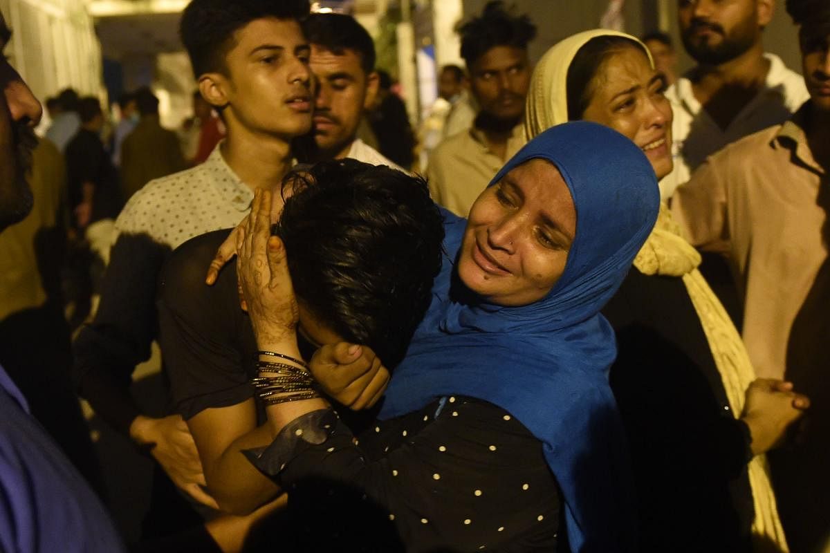 People mourn the death of their relatives killed in a passenger van fire accident, outside a hospital in Pakistan's port city of Karachi. At least 13 people were killed and several others injured when a passenger van overturned and caught fire on a highway at Nooriabad area some 50 kilometers from Karachi, local media reported. Credit: AFP Photo