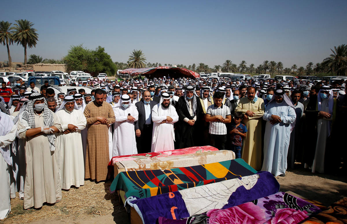 Mourners pray near coffins containing the dead bodies of victims, who were killed in rocket attacks, in Abu Ghraib district, on the outskirts of Baghdad, Iraq. Credit: Reuters Photo