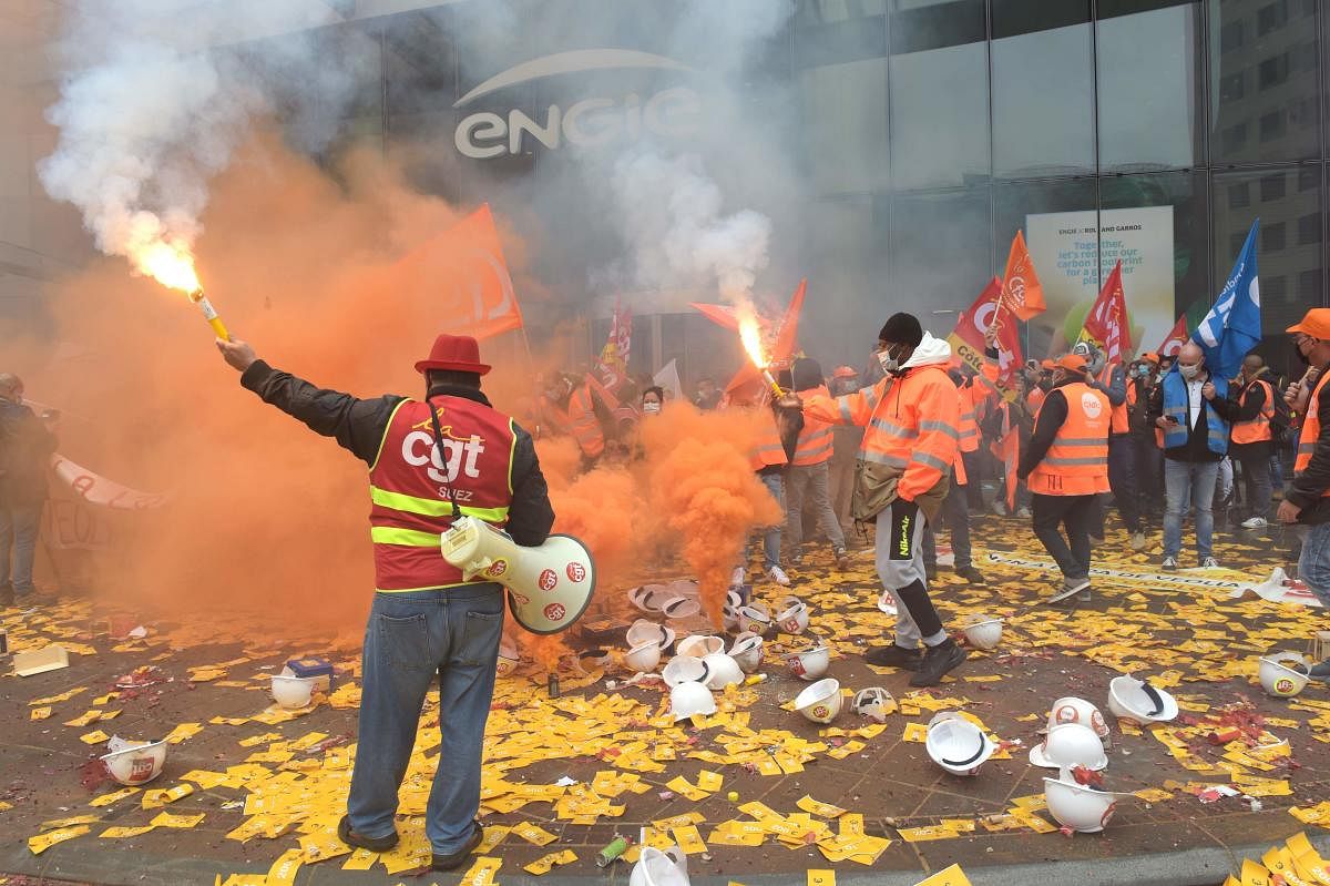 Unions members of Suez hold flares as they demonstrate against against Veolia's takeover bid in La Defense, west of Paris, outside French energy firm Engie, parent company of Suez. Veolia will not extend the September 30 deadline for its offer to Engie to buy back its shares in Suez, its CEO told MPs on September 23, 2020, accusing Suez of pursuing a