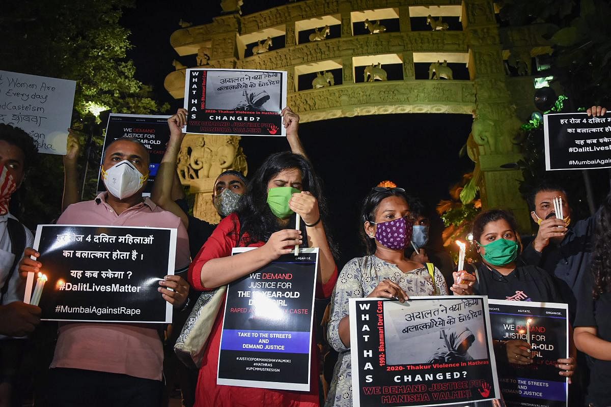 All India Students Federation (AISF) activists hold placards and light candles demanding justice for the Hathras gang-rape victim, in Mumbai, Wednesday. Credit: PTI Photo