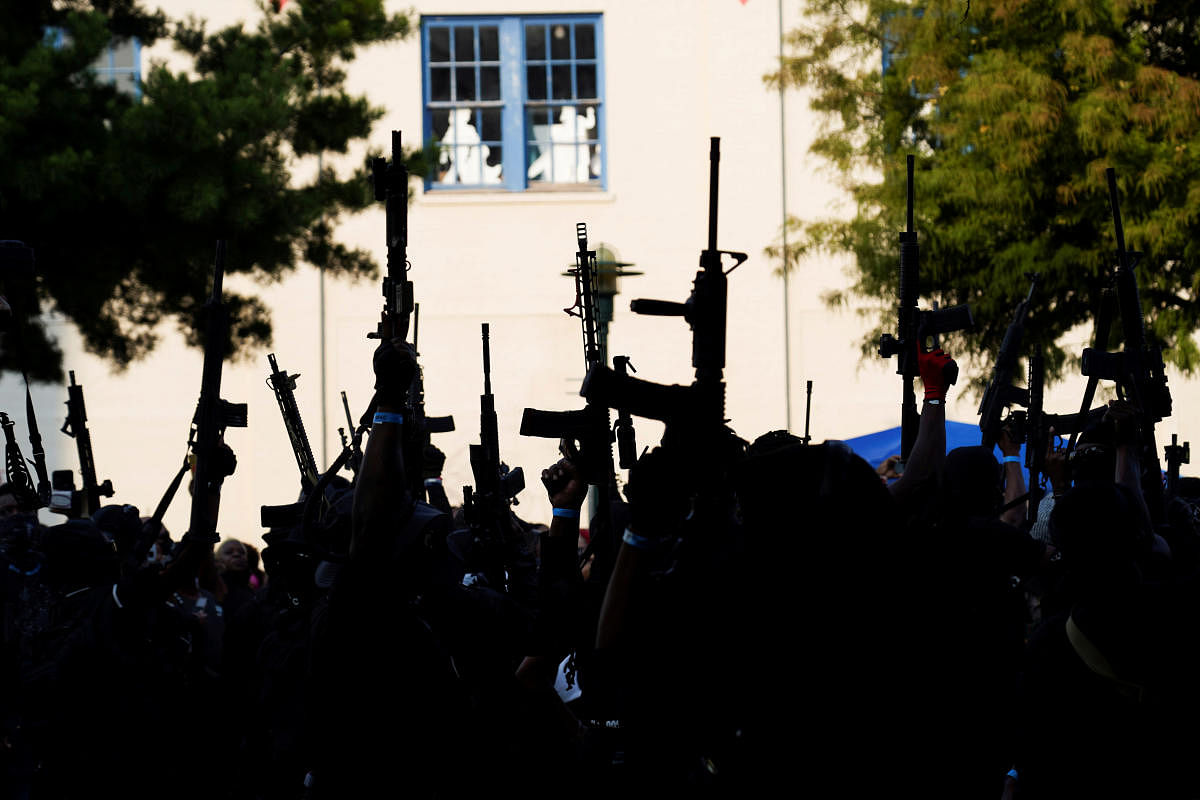 Members of a Black militia group called the NFAC raise their guns while holding an armed rally at Parc Sans Souci in Lafayette, Louisiana, US. Credit: Reuters Photo