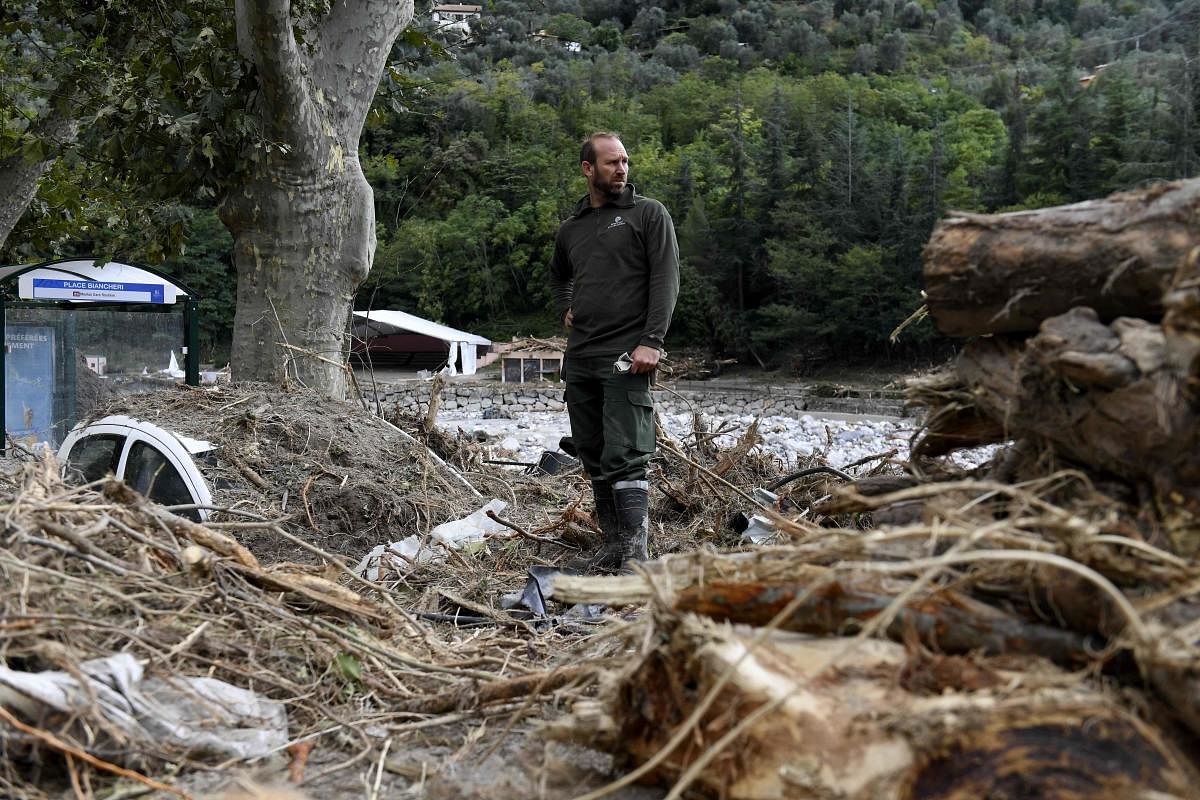 A worker stands near a vehicle covered with debris on a street in Breil-sur-Roya, south-eastern France, after extensive flooding caused widespread damage in the Alpes-Maritimes department. French and Italian rescue services stepped up their search efforts after floods cut off several villages near the two countries' border, causing widespread damage and killing two people in Italy. Credit: AFP Photo