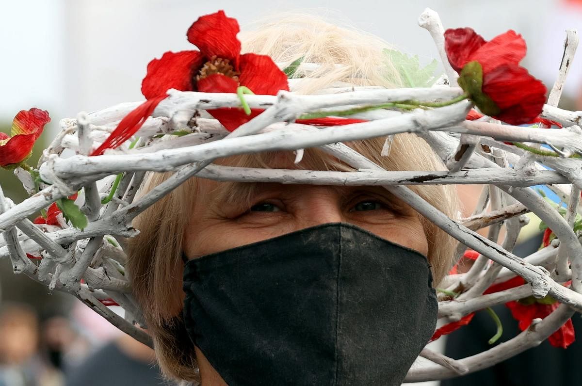 A woman wearing a wreath in colours of a former white-red-white flag of Belarus takes part in a rally demanding to free jailed activists of the opposition in Minsk. Belarusian police used water cannon to disperse a rally in Minsk as tens of thousands of demonstrators took to the streets in the latest weekend protest against strongman Alexander Lukashenko's disputed re-election. Credit: AFP Photo
