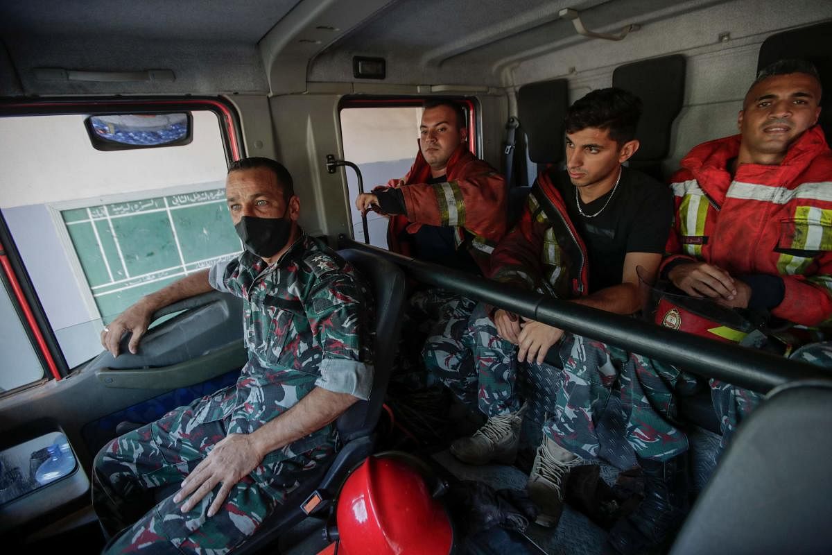 Firefighters of Beirut's fire brigade sit in a truck before heading out from their Karantina neighbourhood headquarters in the Lebanese capital. Sweeping forest fires, a monster explosion that killed friends, then bizarre Beirut blazes: Lebanon's rescuers are still reeling from a devastating year, but are determined to press on. Credit: AFP Photo