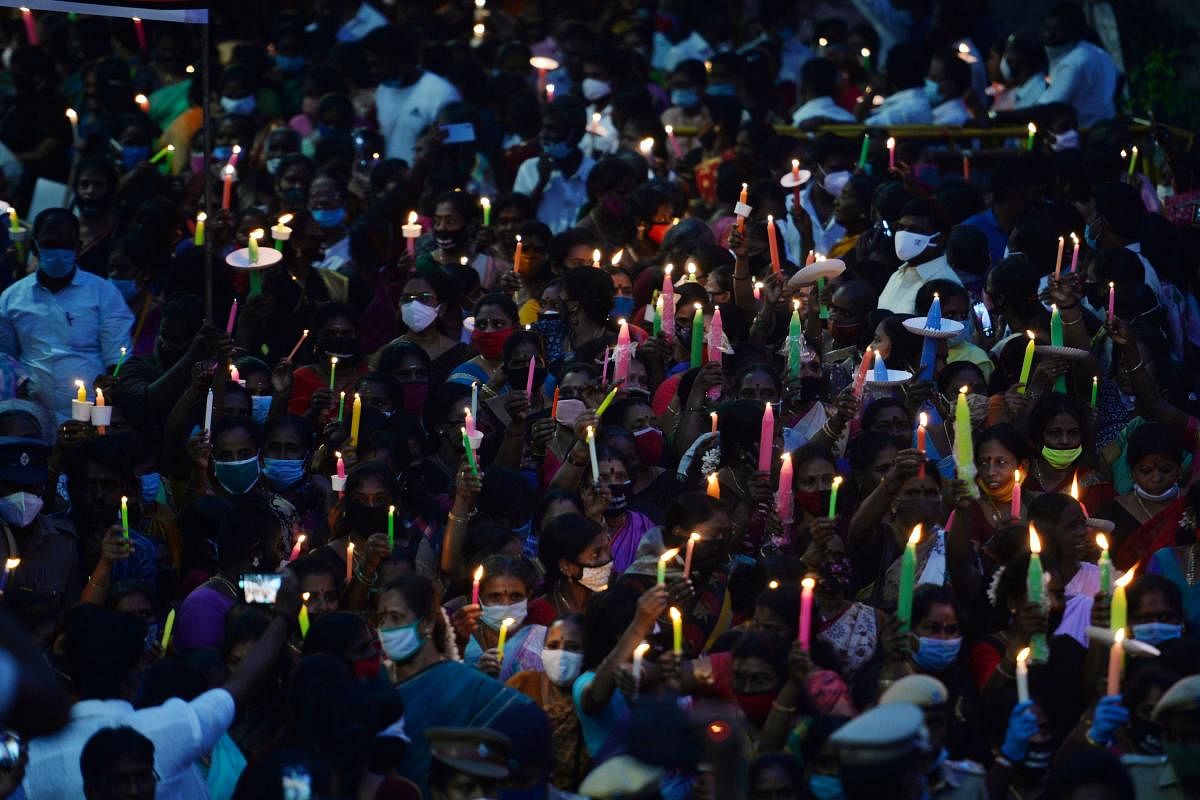 Supporters of the DMK party hold lit candles during a protest march to condemn the alleged gang-rape and murder of a 19-year-old woman in Uttar Pradesh, in Chennai on October 5, 2020. India's federal investigators will take over the probe into the alleged gang-rape and murder of a low-caste teenaged woman that has sparked nationwide outrage and days of protests. Credit: AFP Photo