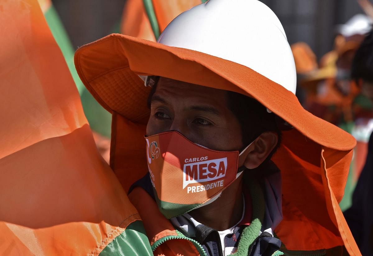 A supporter of Comunidad Ciudadana (CC) party, wears a face mask of Bolivian presidential candidate Carlos Mesa during a rally in El Alto, Bolivia, ahead of general elections. General elections will take place in Bolivia on October 18 amid the new coronavirus pandemic. Credit: AFP Photo