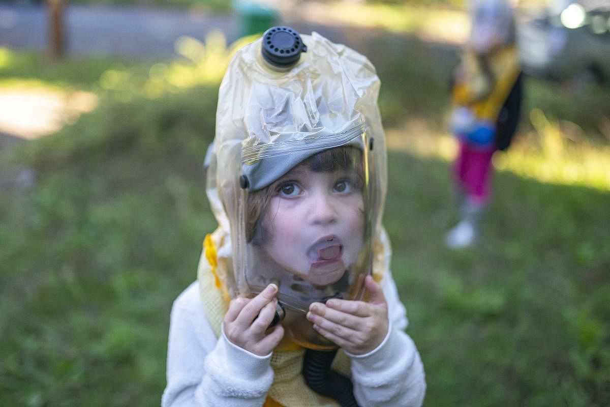 A child examines the inside of her child respirator provided by the non-profit TeamRaccoonPDX in Portland, Oregon. We told them their grandparents sent them space suits to keep them safe, their mother Jessica Walker said of the respirators, which the family sought out after police used tear gas near their residential street. Credit: AFP Photo