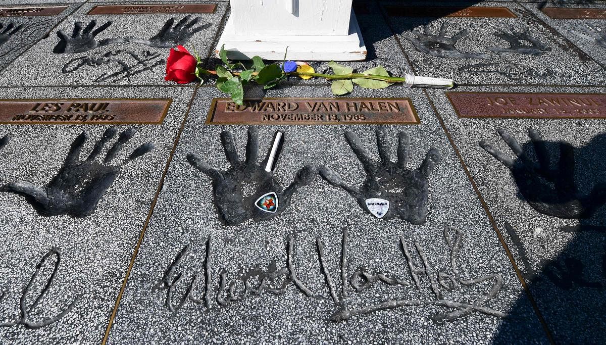 Momentoes including a rose, guitar picks and a cigarette are left on the handprints at the Guitar Center in Hollywood, California of rock guitarist Eddie Van Halen. Van Halen placed his hands in the cement and was inducted into the Hollywood, California RockWalk on November 13, 1985. Eddie Van Halen, the guitar virtuoso whose group is considered one of the greatest rock bands of all time, died on October 6, following a long battle with cancer, his son announced. Credit: AFP Photo
