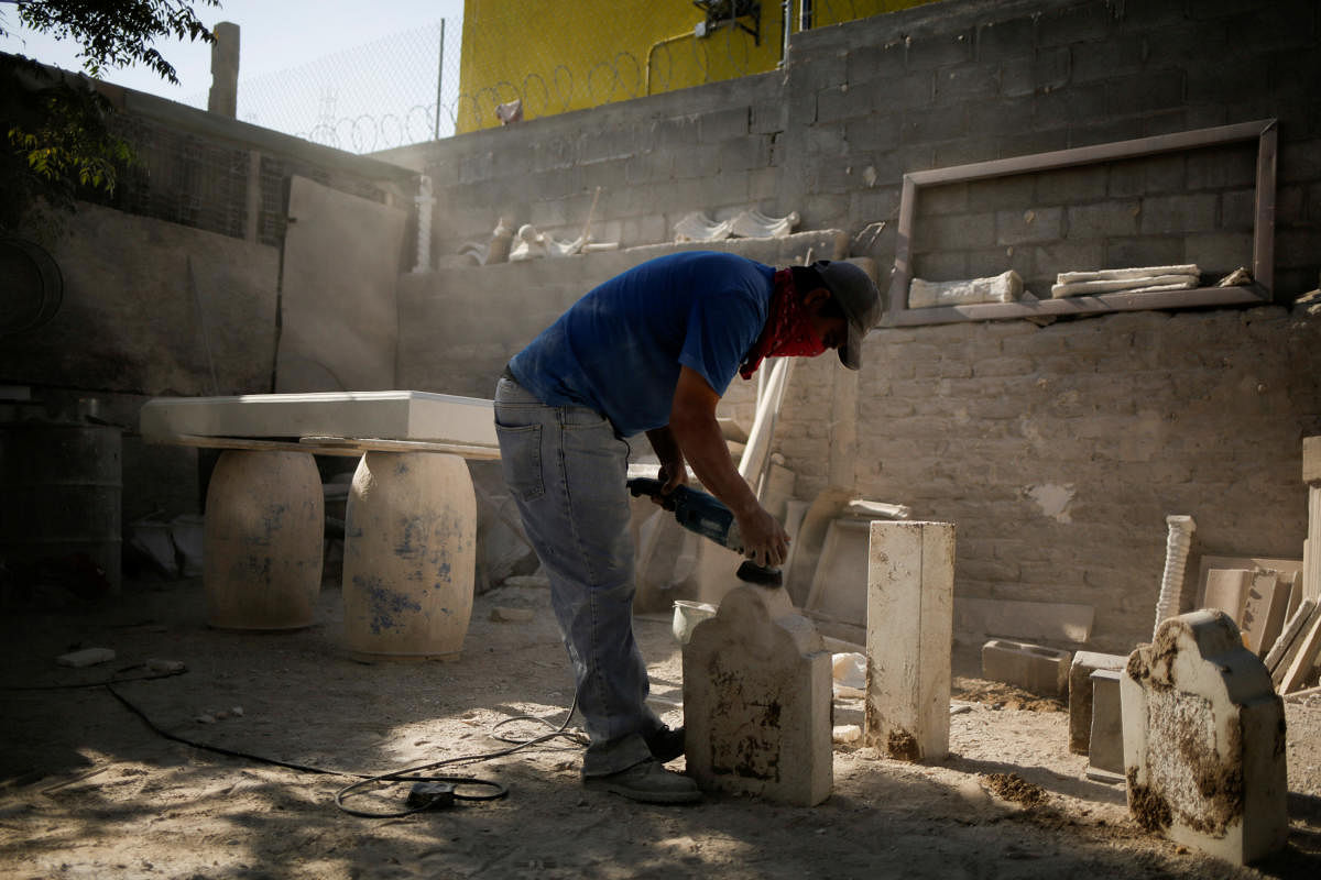 A worker builds a tombstone at a business outside the Colinas de Juarez cemetery, as the coronavirus outbreak continues in Ciudad Juarez, Mexico. Credit: Reuters Photo