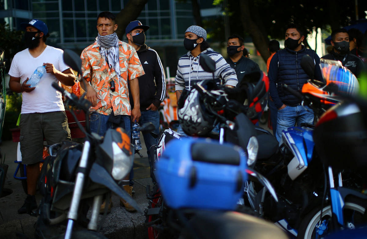 People look on as delivery riders join a global strike to demand better working conditions, at the Angel of Independence Monument in Mexico City, Mexico. Credit: Reuters Photo