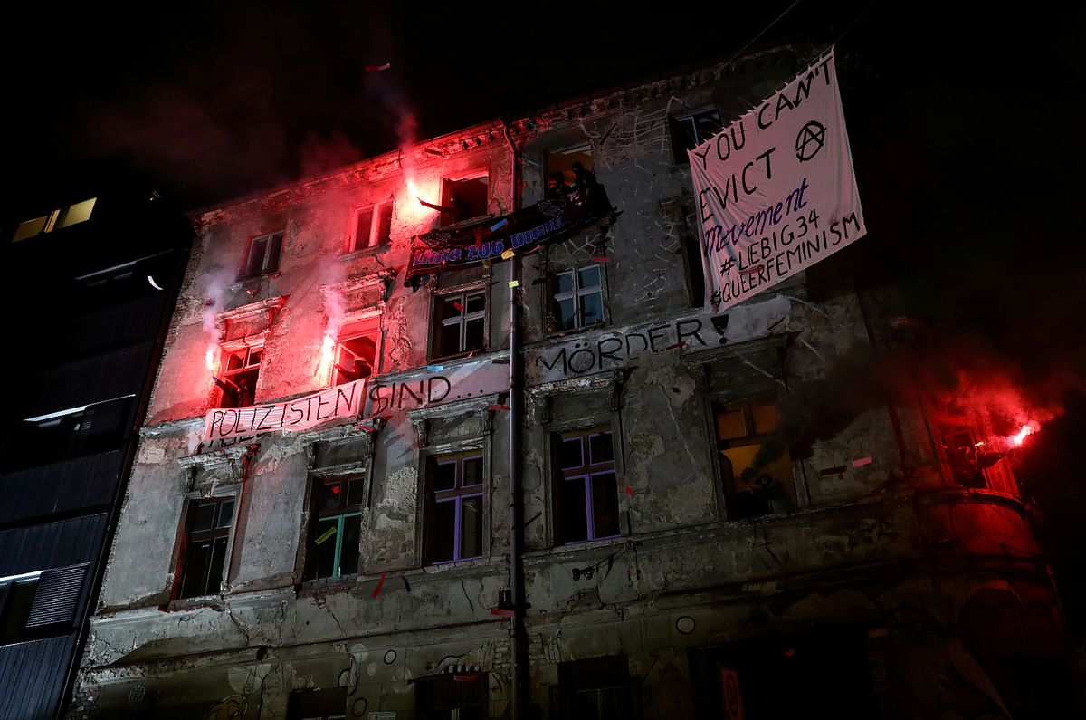 People set off flares from the windows during a demonstration in Berlin Mitte, after the left-wing housing project Liebigstrasse 34 was evicted by police, in Berlin. Credit: Reuters Photo