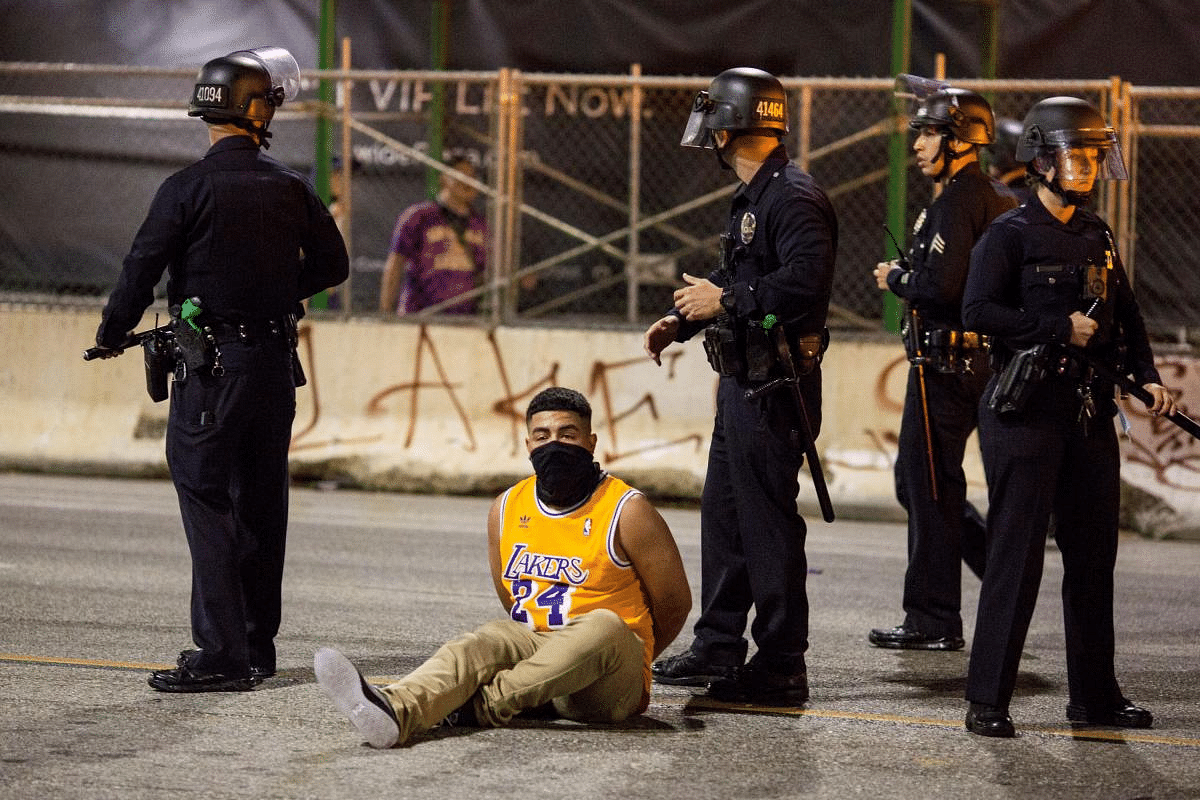 A man is detained by police outside the Staples Center as Los Angeles Lakers fans celebrate their team winning the 2020 NBA Championship against Miami Heat. Credit: Reuters Photo