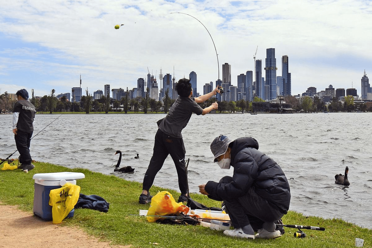 People fish on Melbourne's Albert Park Lake on October 12, 2020, as they use their two hours daily exercise allowed during the stage four restrictions due to the Covid-19 outbreak. Credit: Reuters Photo