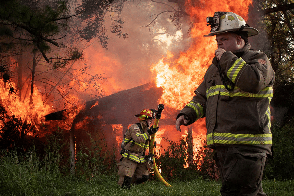 Local firefighters Richard LeBlanc and Richard Devlin respond to a house fire in the aftermath of Hurricane Delta in Lafayette, Louisiana, U.S., October 11, 2020. The fire was most likely caused by a damaged electrical line, firefighters on the scene said. Credit: Reuters Photo