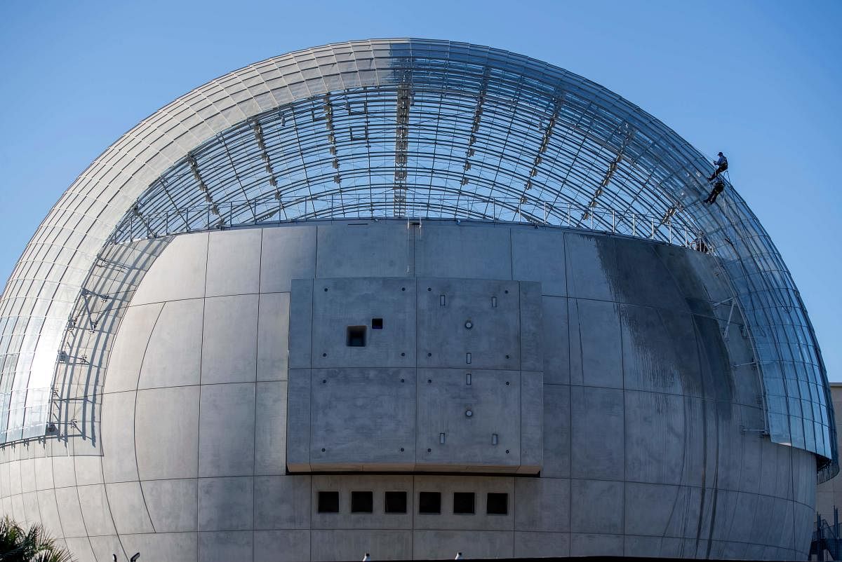 Workers clean the roof of the new Academy Museum of Motion Pictures, amid the coronavirus pandemic, in Los Angeles, California. Credit: AFP Photo