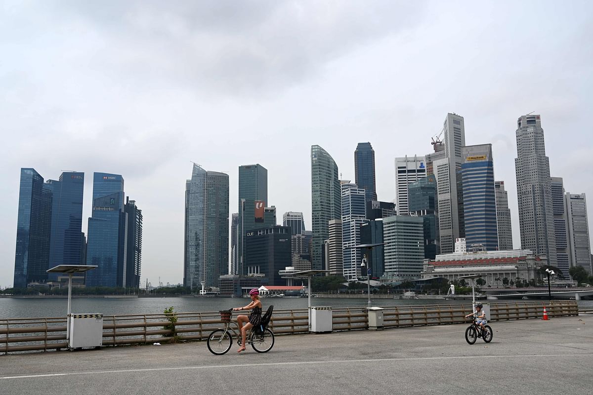 People ride bicycles along Marina Bay in Singapore. Credit: AFP Photo