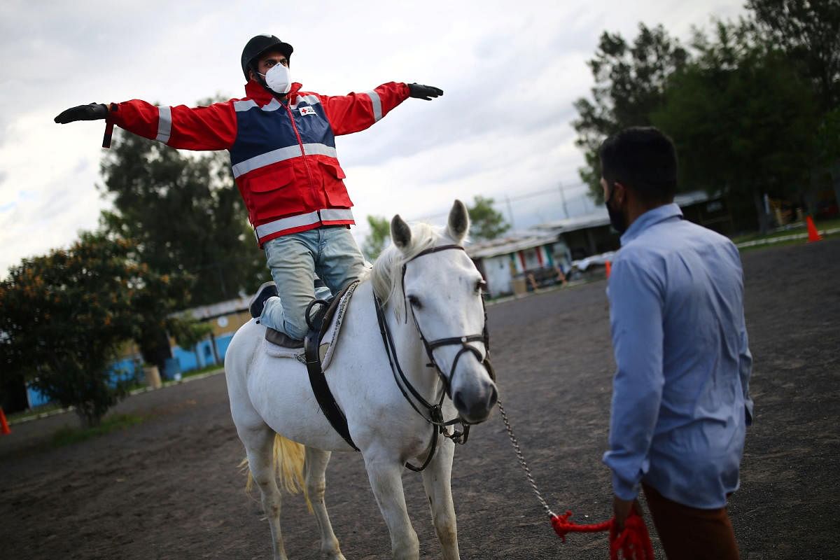 Rafael Aguilar, 32, a health worker and patient, rides on a horse named