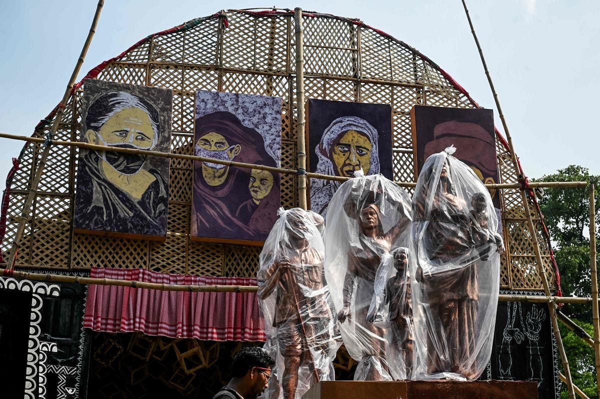 Models of migrant labourers used as a theme decoration to create awareness about the migrant labourers' social issues during the lockdown previously imposed due to the coronavirus pandemic are kept under plastic sheets at a makeshift place for worship ahead of the Hindi festival 'Durga Puja' in Kolkata. Credit: AFP Photo
