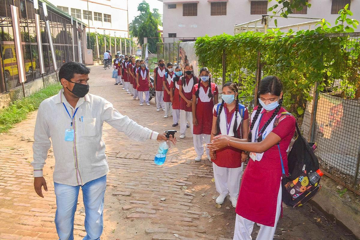 Students undergo thermal screening after authorities allowed resumption of classes for senior students of class 9 to 12 with certain restrictions in Varanasi. Credit: PTI