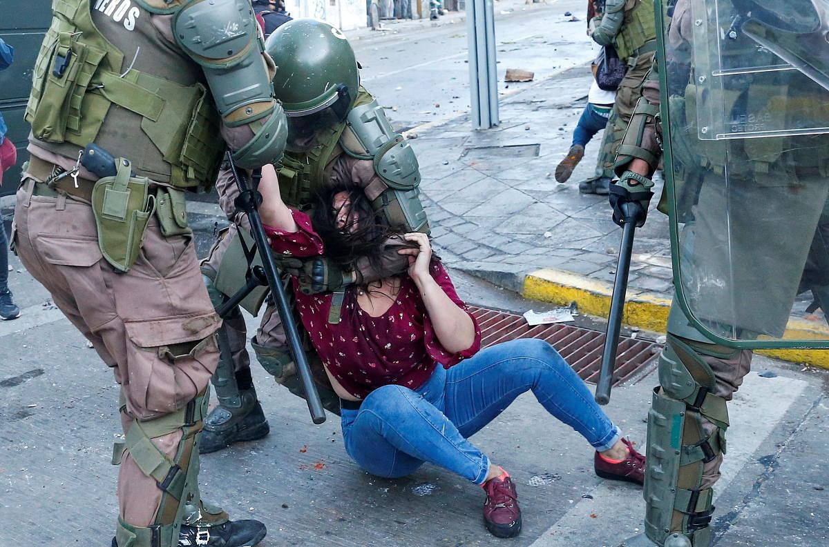 A demonstrator is detained by riot police during a protest against Chile's government in Valparaiso, on the one-year-anniversary of the protests and riots in 2019. Credit: Reuters Photo 