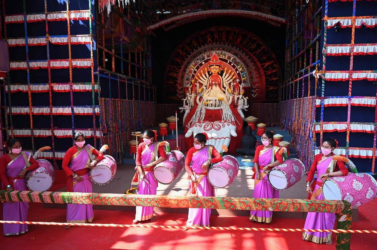 Traditional drummers play perform near an idol of the ten-armed Hindu Goddess Durga at a makeshift place for worship ahead of the Hindu festival 'Durga Puja' in Kolkata. Credit: AFP Photo