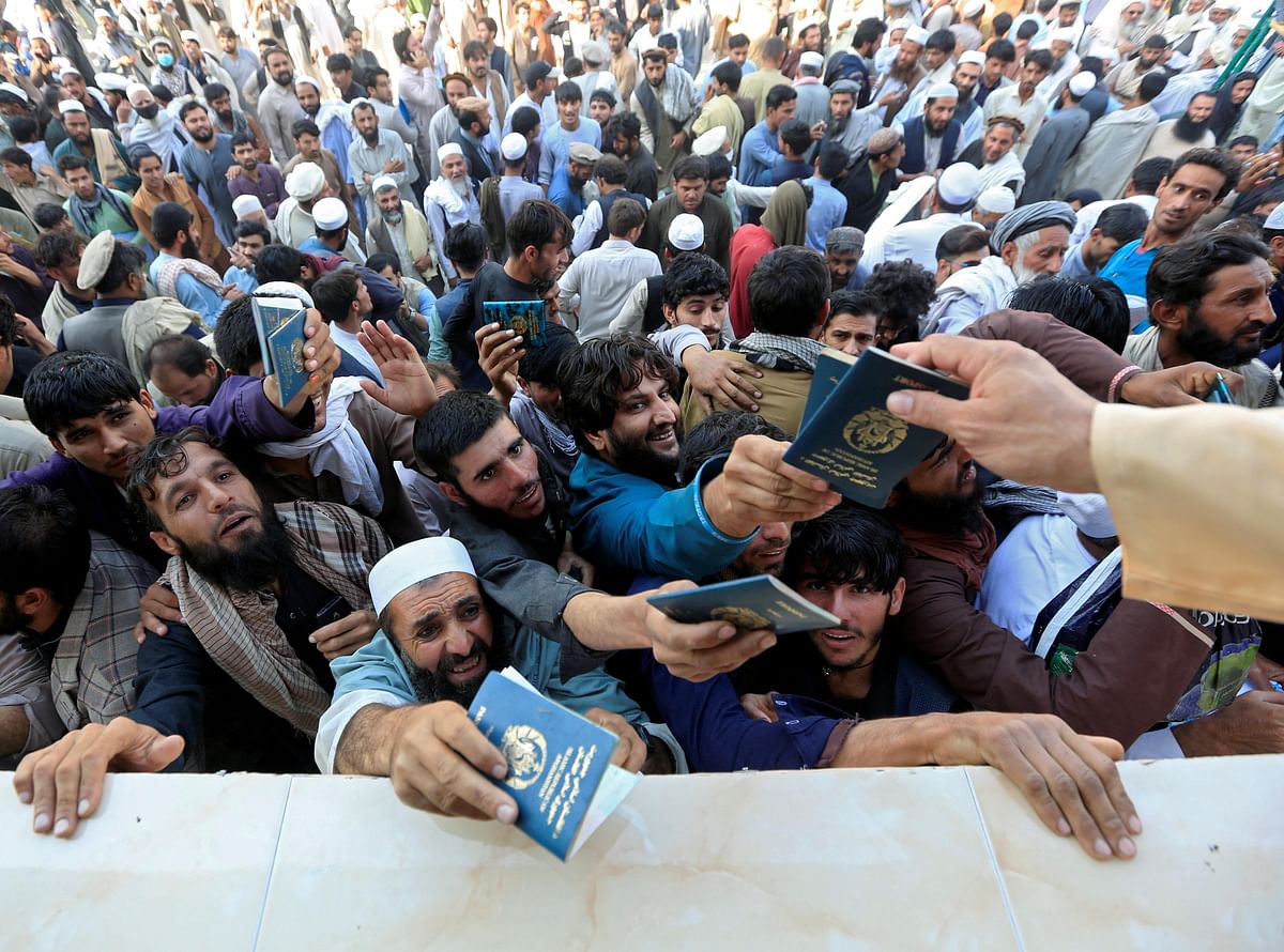 Afghan men wait to collect tokens needed to apply for the Pakistan visa, in Jalalabad, Afghanistan. Credit: Reuters Photo