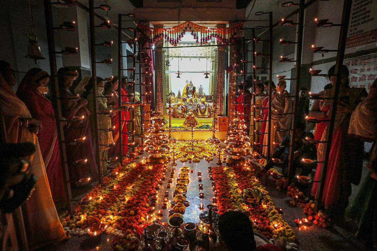 Devotees offer prayers after lighting oil lamps at Goddess Sheetla Mata Temple during the ongoing Navratri festival, in Bhopal. Credit: PTI Photo