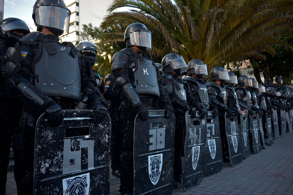 Riot police stand guard during a protest of members of labor unions, teachers and university students against the economic measures of the government of Ecuadorian President Lenin Moreno in downtown Quito. Credit: AFP Photo