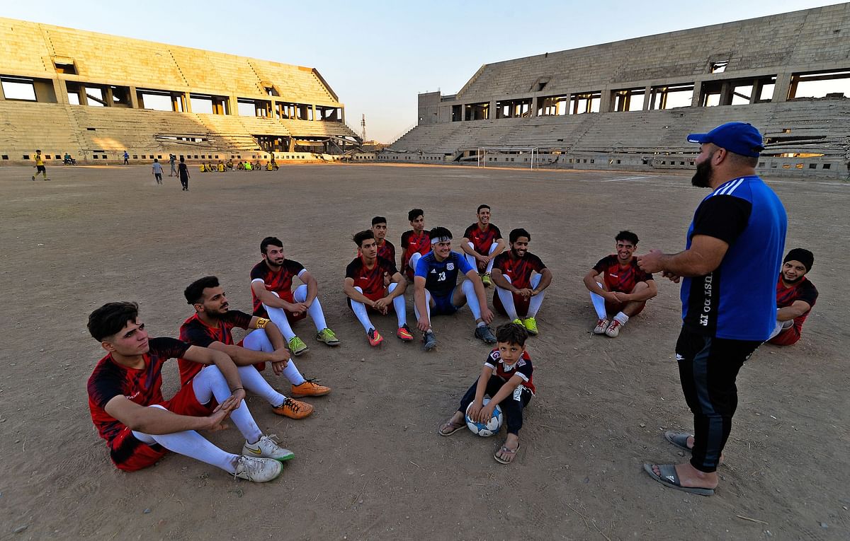 Mohamed Fathi, coach of Al-Mosul FC, speaks with his team players at the ravaged al-Idara al-Mahalia stadium, which was once used by Islamic State group fighters as a weapons depot, near the northern Iraqi city of Mosul. Credit: AFP Photo