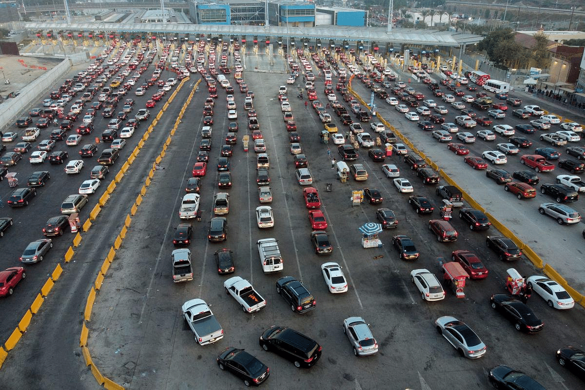 Aerial view of cars lining up to cross the US/Mexico border to San Diego at San Ysidro port of entry, in Tijuana, Baja California state, Mexico, on October 6, 2020. - People who have both, the Mexican and the US citizenships, are concerned about the upcoming elections in the United States. Credit: AFP Photo