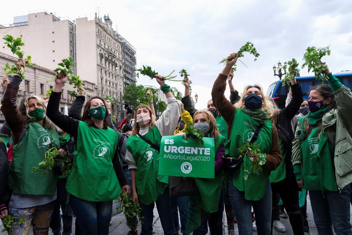 Activists for a National Campaign for a Legal, Safe and Free Abortion wave parsley, sometimes used to induce a miscarriage, during a demonstration in favour of legalising abortion, outside the National Congress, in Buenos Aires, Argentina. Credit: Reuters Photo