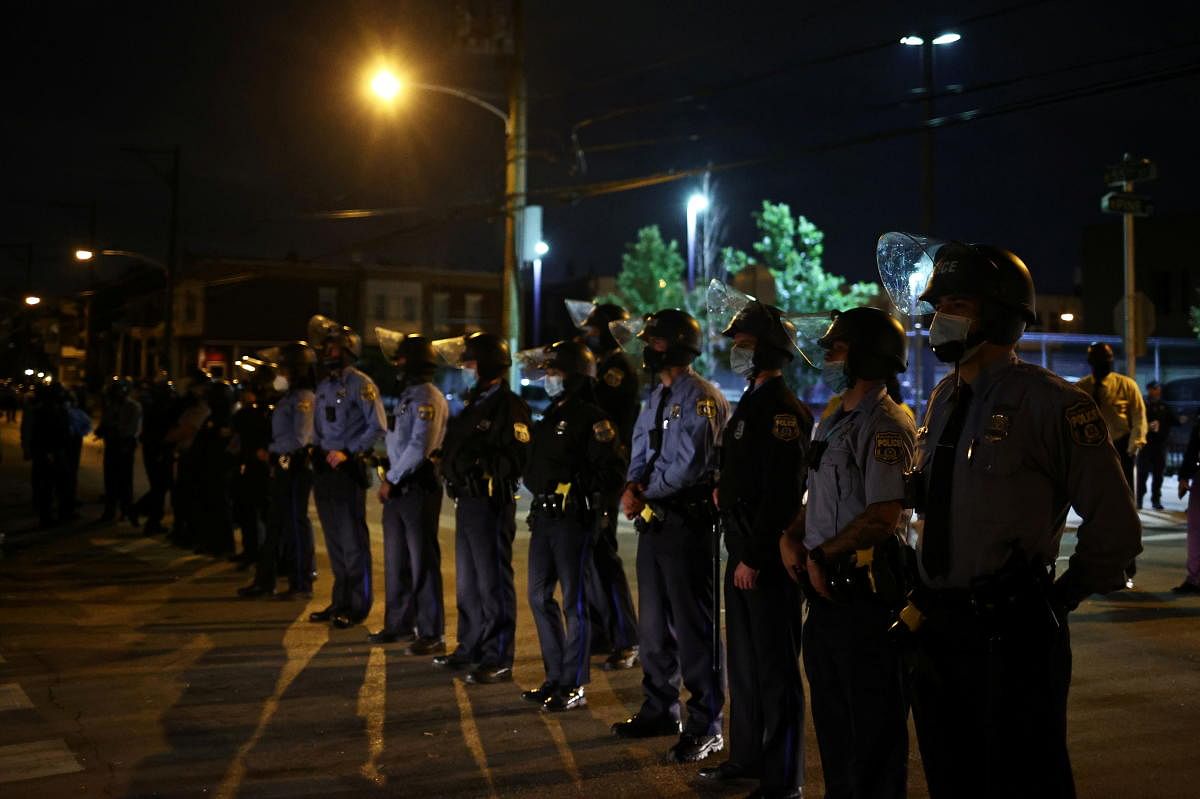 Police officers stand guard outside a police station after the death of Walter Wallace Jr., a Black man who was shot by police in Philadelphia, Pennsylvania. Credit: Reuters Photo